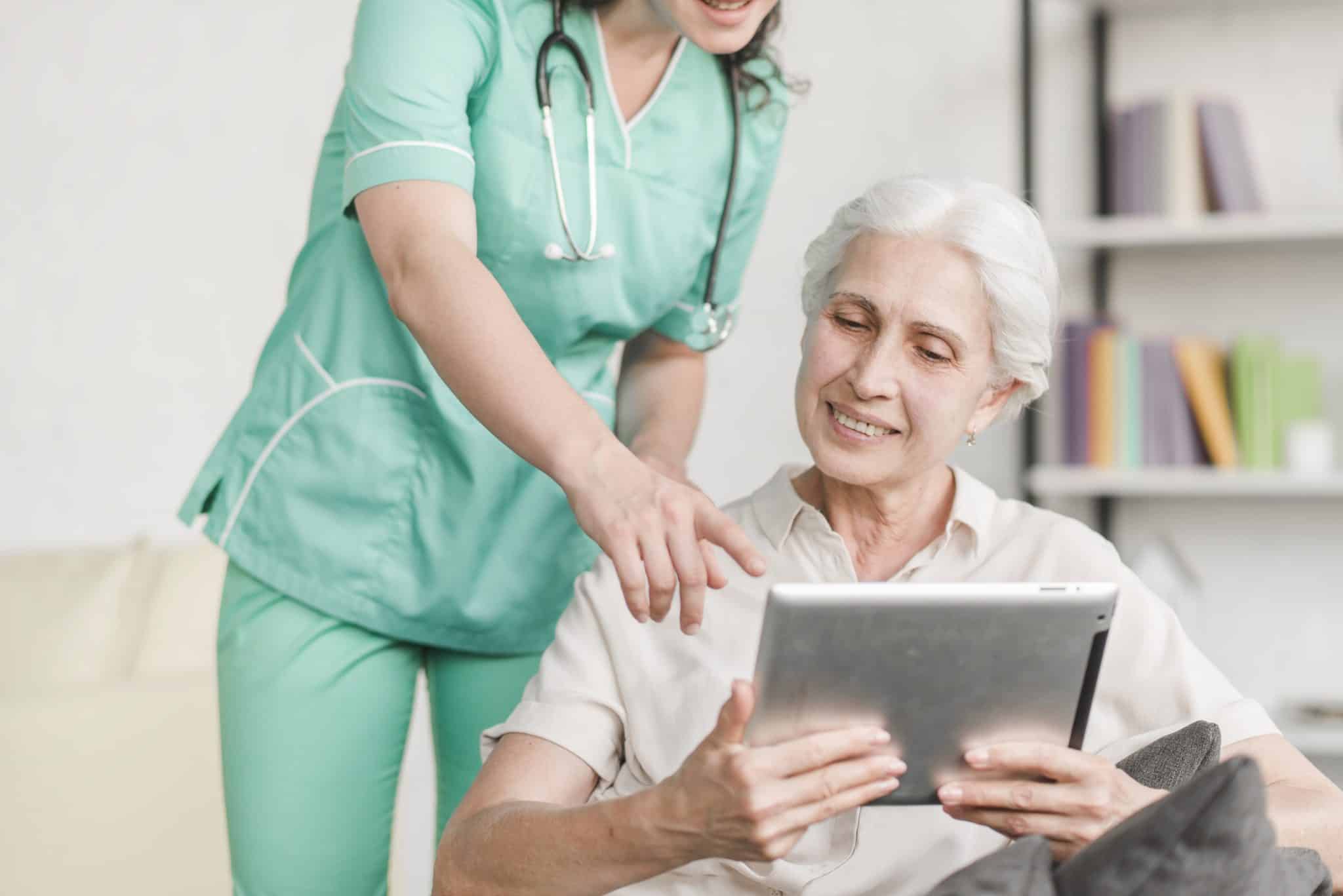 infirmiere-montrant-quelque-chose-patiente-senior-tablette-numerique